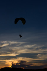Fototapeta na wymiar Silhouette paramotor / paraglider flying on the sky with seavie