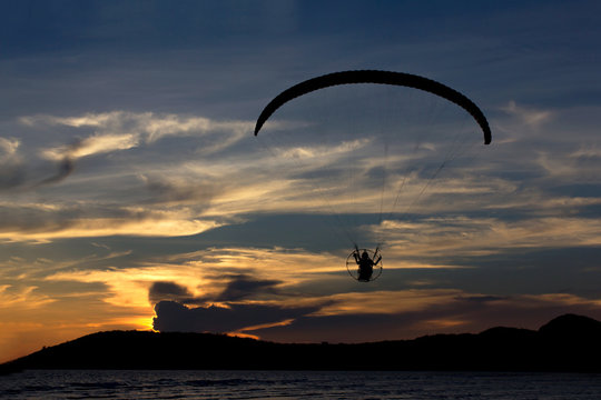 Silhouette paramotor / paraglider flying  on the sky with seavie
