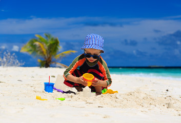 Fototapeta na wymiar child playing on sand beach