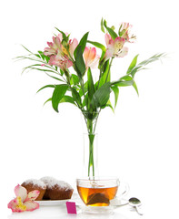 Appetizing cupcake on a dish, tea and alstroemeria