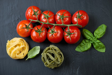 Red tomatoes with tagliatelle and green basil, view from above