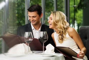 Cheerful couple with menu in a restaurant