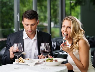 Couple eating in restaurant with a red wine