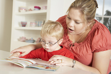 Mother and Downs Syndrome son reading