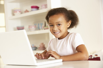 Young girl working on laptop at home