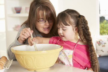 Girl with Downs Syndrome baking with mother