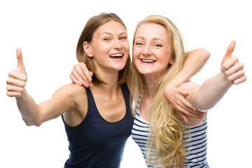 Fototapeta na wymiar Two young happy women showing thumb up sign