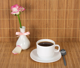 Vase with rose, white coffee cup