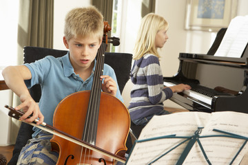 Boy and girl playing cello and piano at home