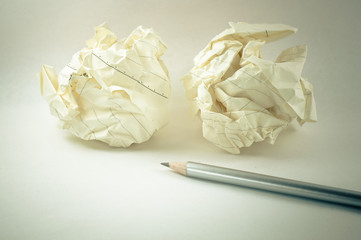 Crumpled paper ball with a pencil in white background