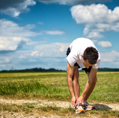 Sportsman bending over tying his laces
