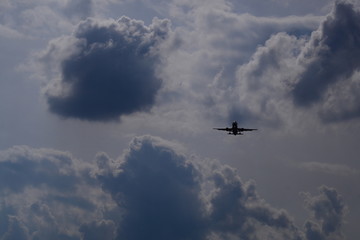 Fototapeta na wymiar plane flies under gray clouds
