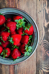 Strawberries in a bowl on wooden background
