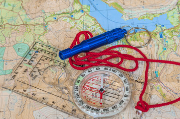 Fototapeta na wymiar Compass on Map and Rescue Whistle