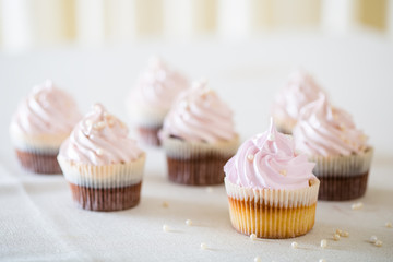Pink cupcakes at white table  in high light style.