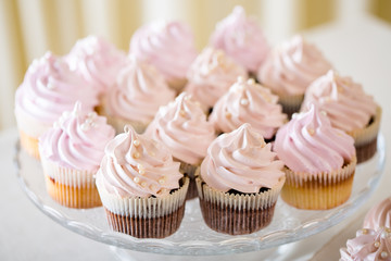 Pink cupcakes at white table  in high light style.