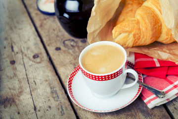 Breakfast setting: cup of coffee and croissants, toned
