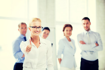 Obraz premium businesswoman in office showign thumbs up