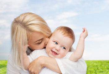 happy mother kissing smiling baby