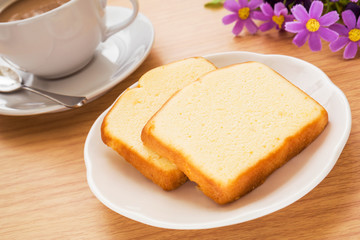 Butter cake sliced on plate and coffee cup