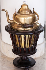 Shining Arabic teapot on dark wooden base