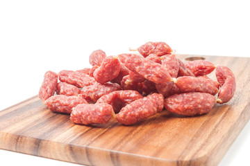 A heap of mini Salamis on wooden board