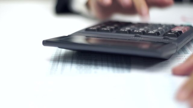 Businessman working with data sheet and using calculator