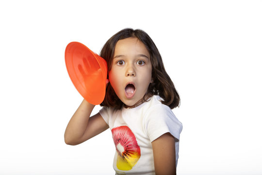 Ni&ntilde;a con trompetilla escuchando con asombro