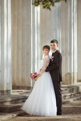 Naklejka premium Bride and groom at wedding day kissing at park