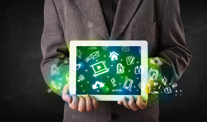 Fototapeta na wymiar Person holding tablet with green media icons and symbols