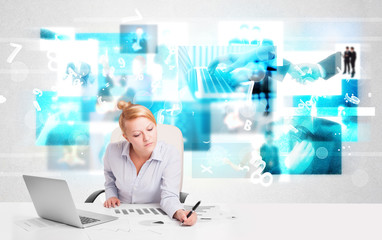 Business person at desk with modern tech images at background