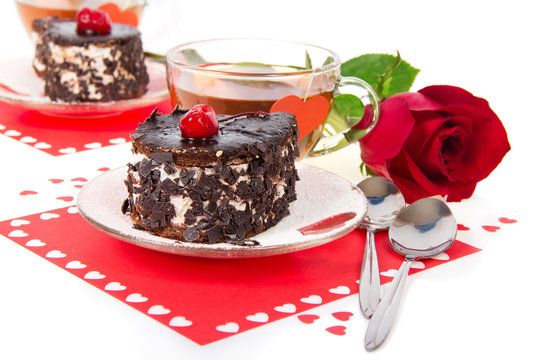 Chocolate cherry cakes, hot tea and red rose