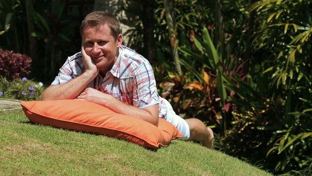 Man lying on grass and smiling to the camera