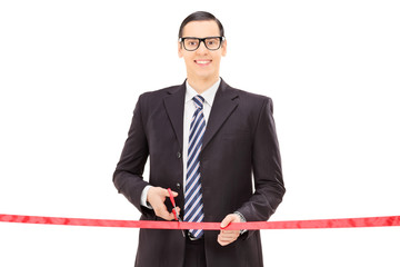 Businessman cutting a red tape