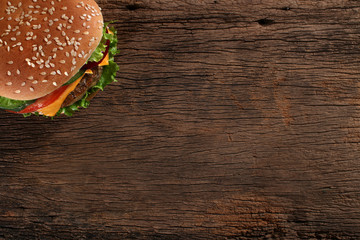 Tasty hamburger on wood background. Space for text - obrazy, fototapety, plakaty