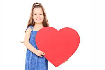 Little girl holding a big red heart