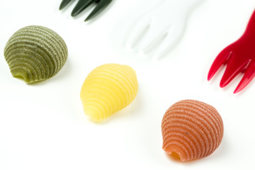 Uncooked Italian conchiglie pasta on a white background