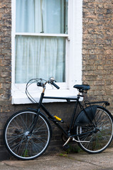 Fototapeta na wymiar Old bike by the window of a cottage