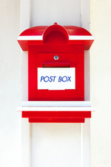 Red wooden mail box on white wall