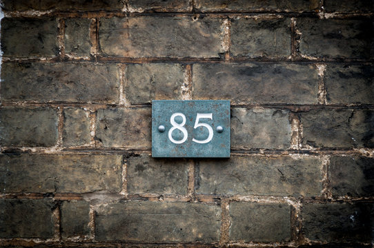 Close Up Of Number 85 On A Brick Wall