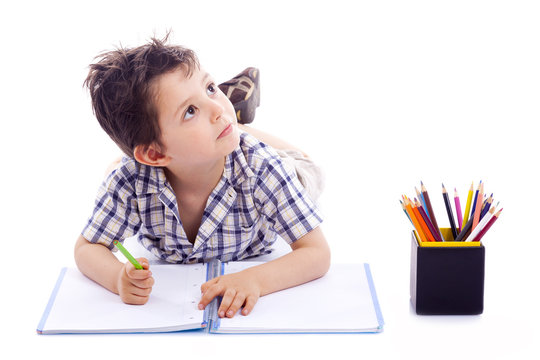 Schoolboy drawing with colored pencils, isolated on white backgr