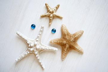 Fototapeta na wymiar starfishes on a white wooden background with turquoise drops