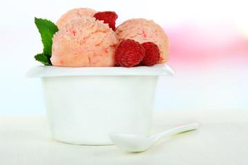 Tasty ice cream scoops in bowl, on wooden table