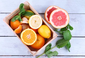Rolgordijnen Fresh citrus fruits with green leaves in wooden box © Africa Studio