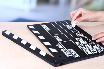 Black cinema clapper board in hands, close up