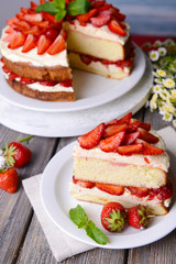 Delicious biscuit cake with strawberries on table close-up