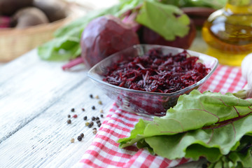 Grated beetroots in bowl on table close-up