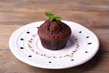 Chocolate muffin on plate wooden background