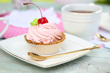 Tasty cake and cup with tea on table, close-up, outdoors
