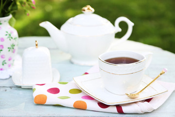 Teapot and cup on table, close-up, in garden